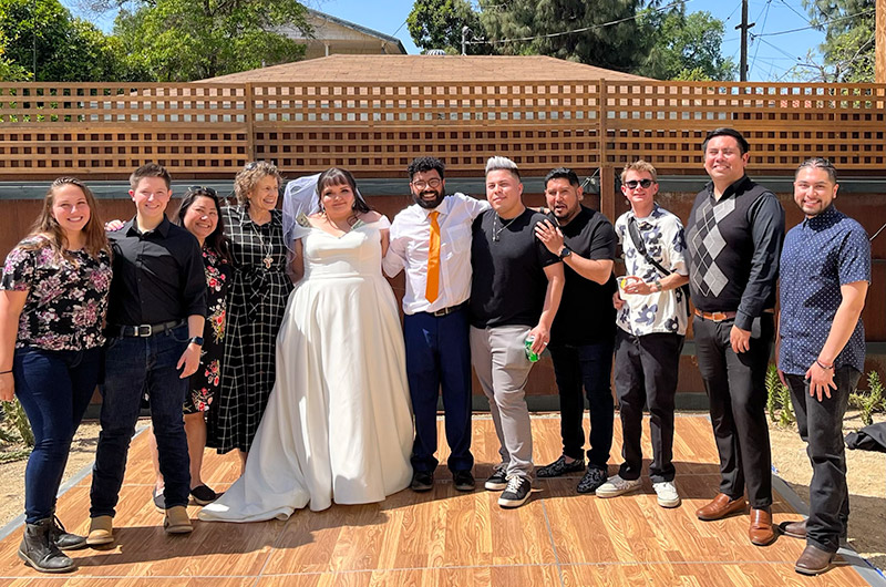 group of young adults gather around the bride and groom