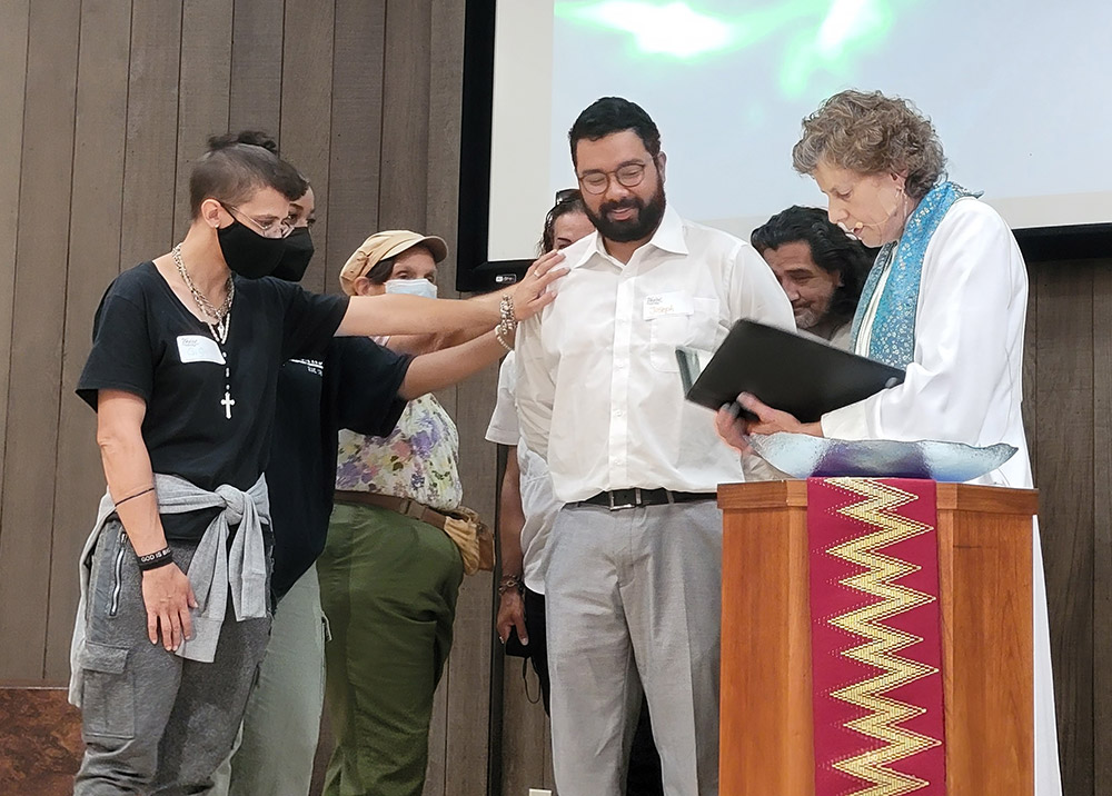 worship service with congregation looking at the speaker who is reading a prayer